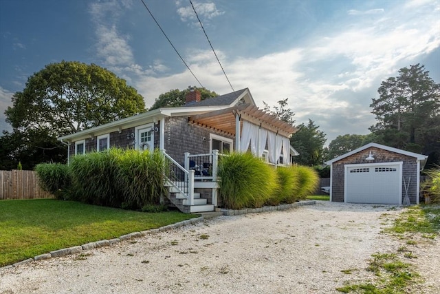 view of front of home featuring a garage, an outdoor structure, and a front yard