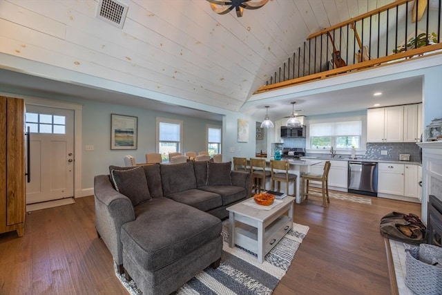 living room featuring dark wood-type flooring, vaulted ceiling, sink, and wooden ceiling