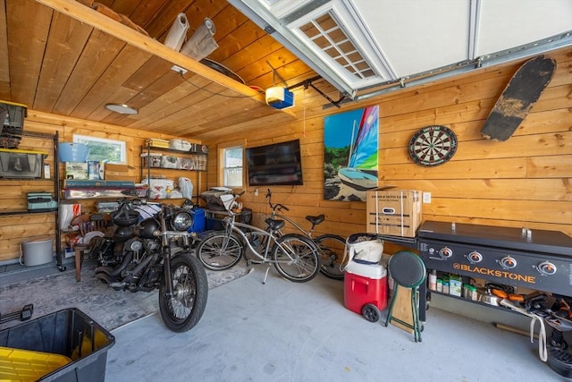 garage with a garage door opener, wood ceiling, and wooden walls