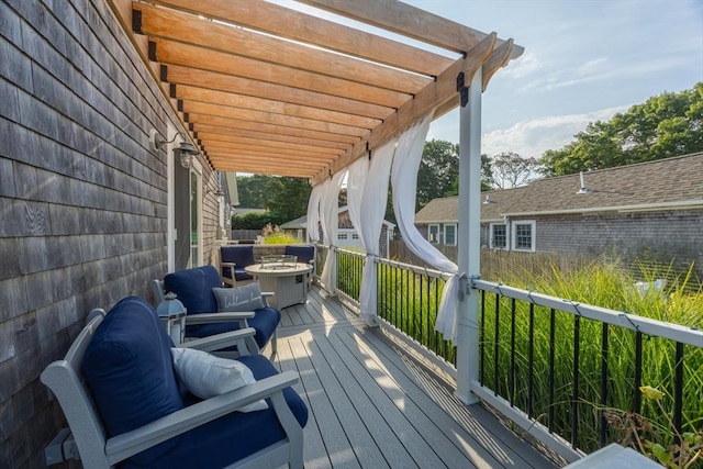 wooden deck featuring a fire pit and a pergola