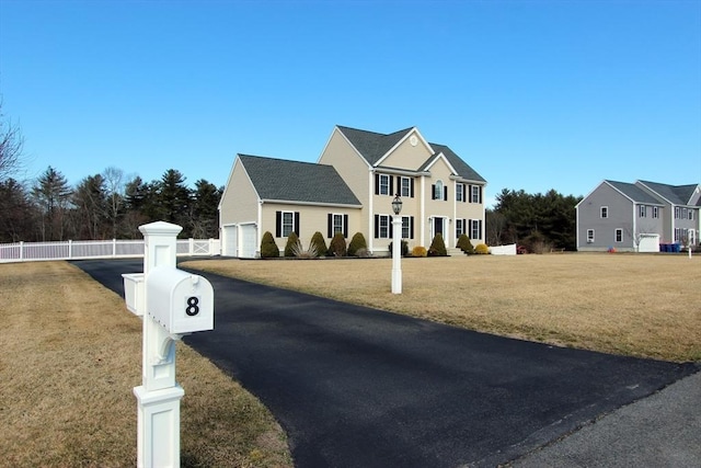 exterior space featuring a front yard, fence, and a garage