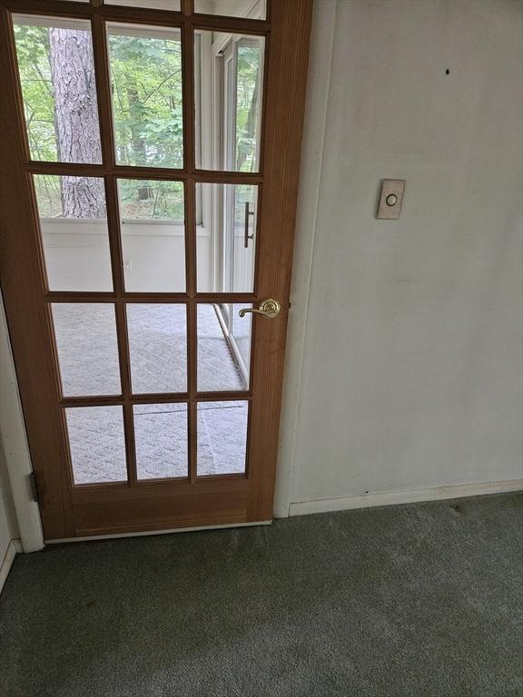 59 Tanbark Rd, Sudbury, MA 01776 - doorway featuring dark carpet and baseboards