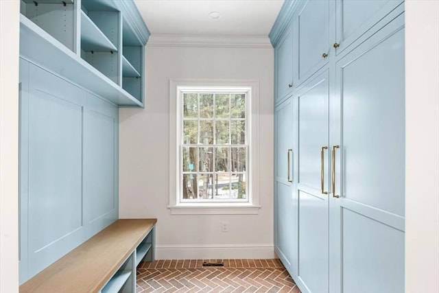 mudroom featuring brick floor, plenty of natural light, baseboards, and crown molding