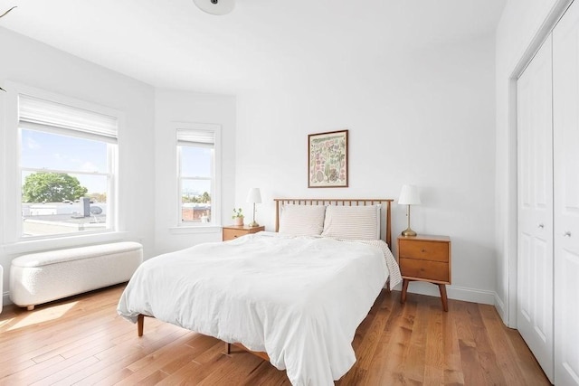 bedroom featuring a closet, wood finished floors, and baseboards