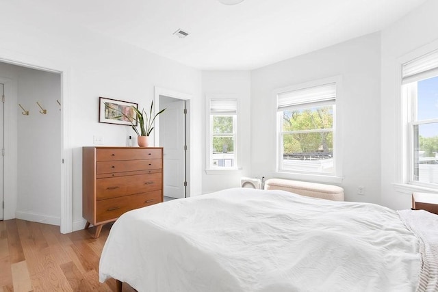 bedroom with light wood-type flooring and baseboards