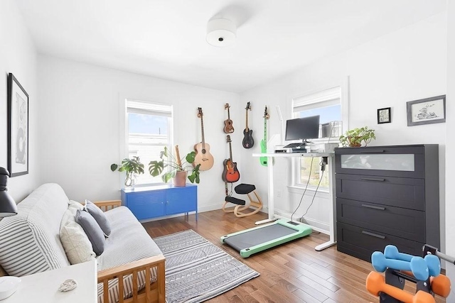 workout room featuring wood finished floors and baseboards