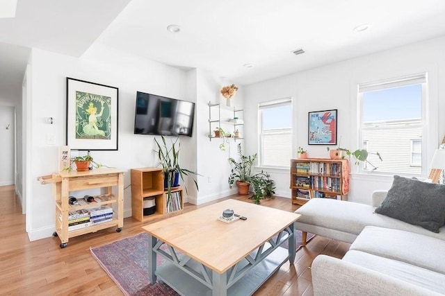 living area featuring light wood-style flooring, baseboards, and recessed lighting