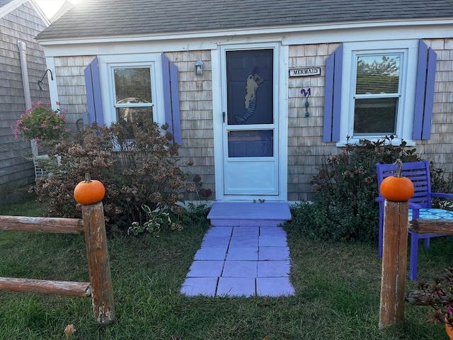 entrance to property featuring a lawn