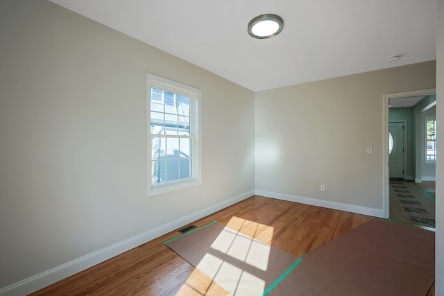 unfurnished room featuring a healthy amount of sunlight and hardwood / wood-style flooring