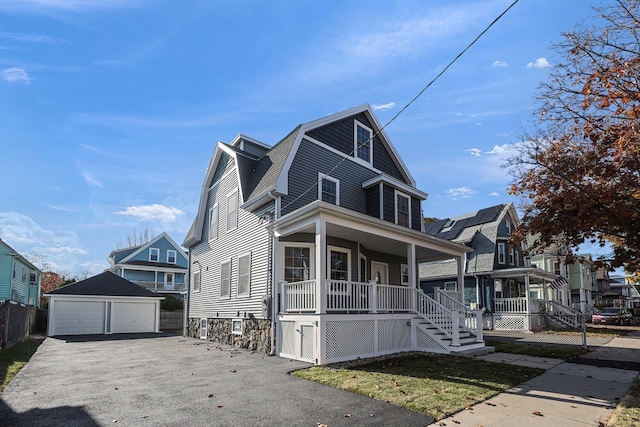 front facade with covered porch, an outdoor structure, and a garage