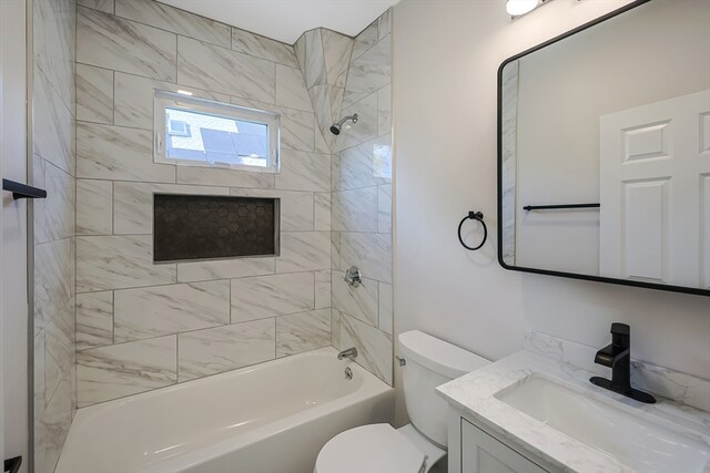 full bathroom with vanity, tiled shower / bath combo, and toilet