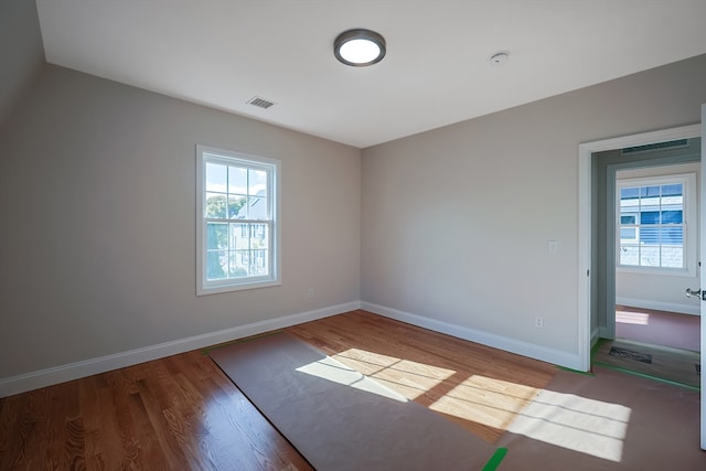 spare room with hardwood / wood-style flooring and plenty of natural light