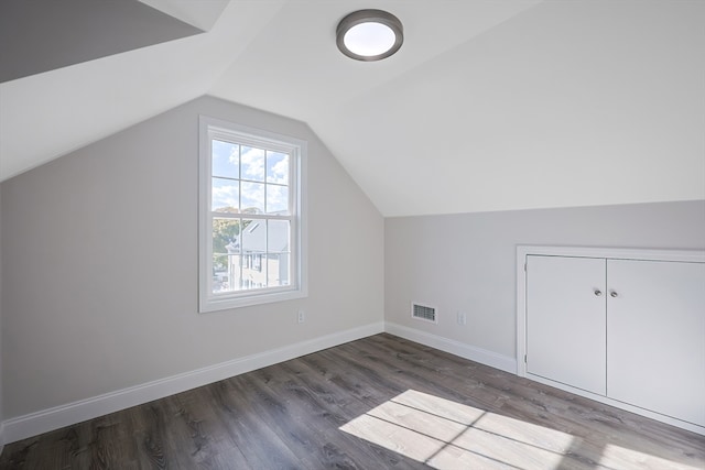 bonus room with lofted ceiling and dark hardwood / wood-style flooring