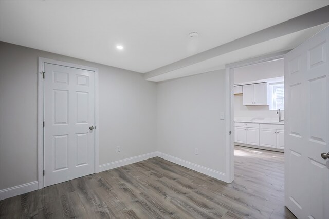 basement with light hardwood / wood-style flooring