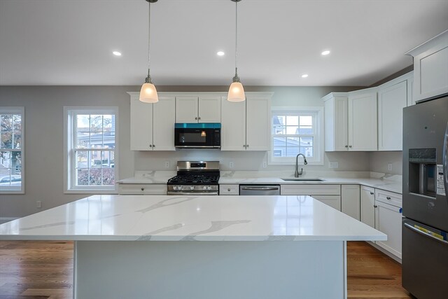 kitchen featuring a kitchen island, stainless steel appliances, sink, and a wealth of natural light