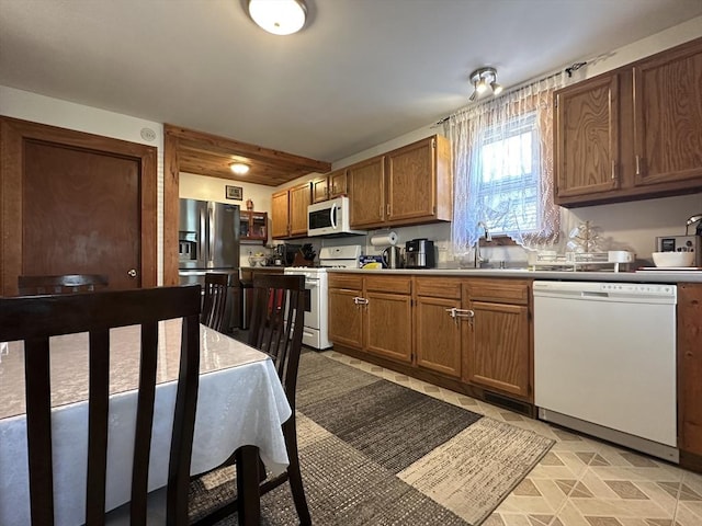 44-46 Spring St, West Springfield, MA 01089 - kitchen featuring white appliances, brown cabinetry, and a sink