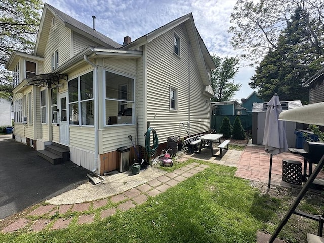 44-46 Spring St, West Springfield, MA 01089 - view of property exterior with entry steps, a patio area, and a chimney