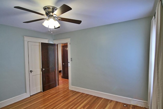 unfurnished bedroom featuring ceiling fan, baseboards, and wood finished floors