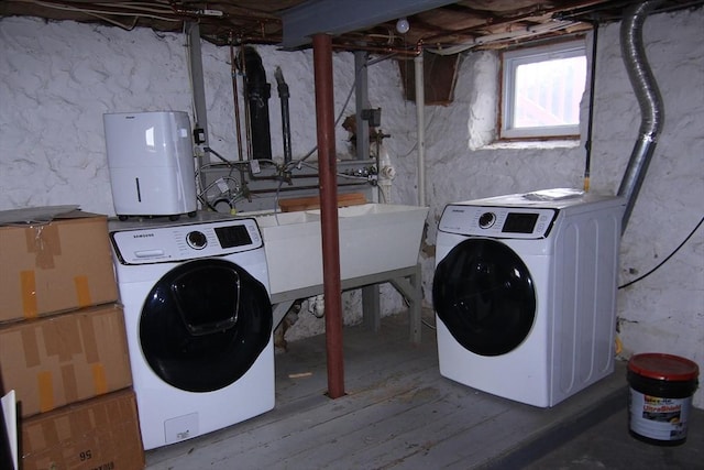 washroom featuring laundry area, separate washer and dryer, and wood finished floors