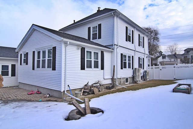 view of snow covered exterior featuring a gate and fence