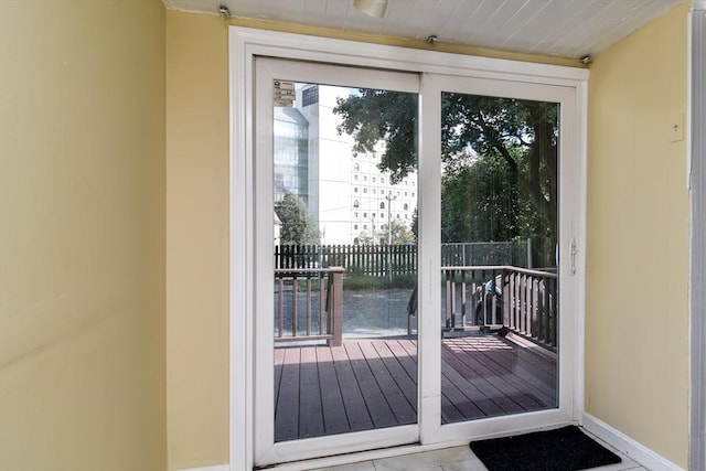 doorway featuring healthy amount of natural light and baseboards