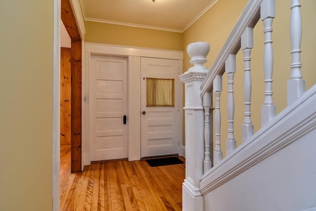 hall with hardwood / wood-style floors, crown molding, and stairway