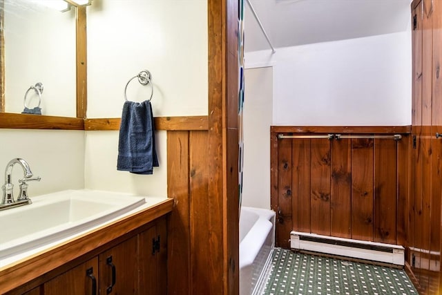 bathroom featuring baseboard heating, a bath, and vanity