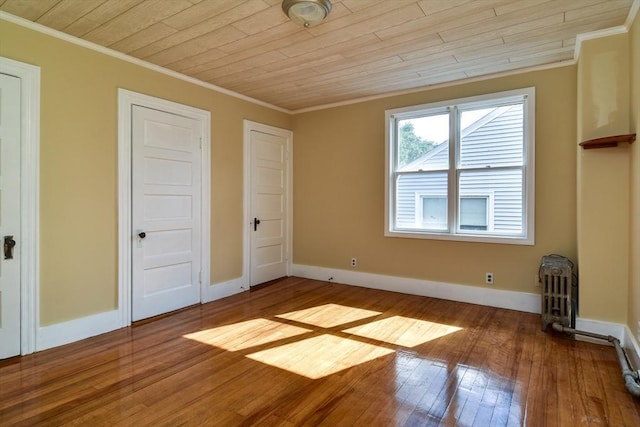 unfurnished bedroom with ornamental molding, hardwood / wood-style flooring, wooden ceiling, and baseboards