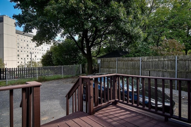 wooden terrace with a fenced backyard