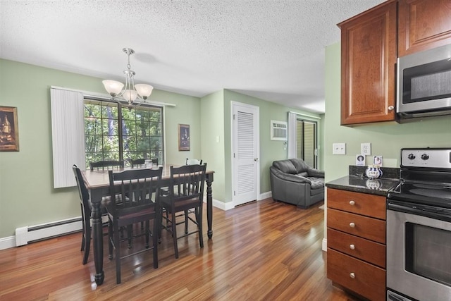 1410 Skyline Dr Unit 11, Lowell, MA 01854 - dining area with a chandelier, wood finished floors, a textured ceiling, baseboards, and a wall mounted AC