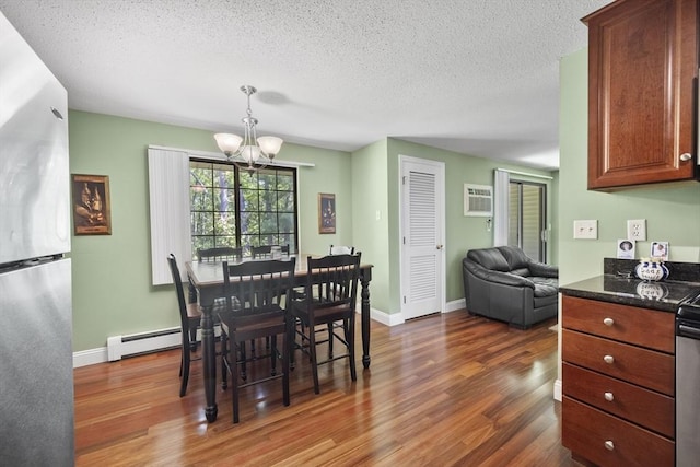 1410 Skyline Dr Unit 11, Lowell, MA 01854 - dining space with a chandelier, dark wood-style flooring, a baseboard heating unit, a textured ceiling, and baseboards
