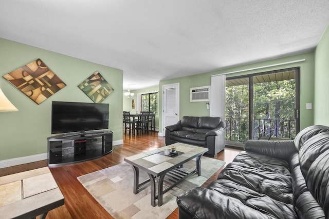 1410 Skyline Dr Unit 11, Lowell, MA 01854 - living room featuring wood finished floors, baseboards, a chandelier, and a wall mounted air conditioner