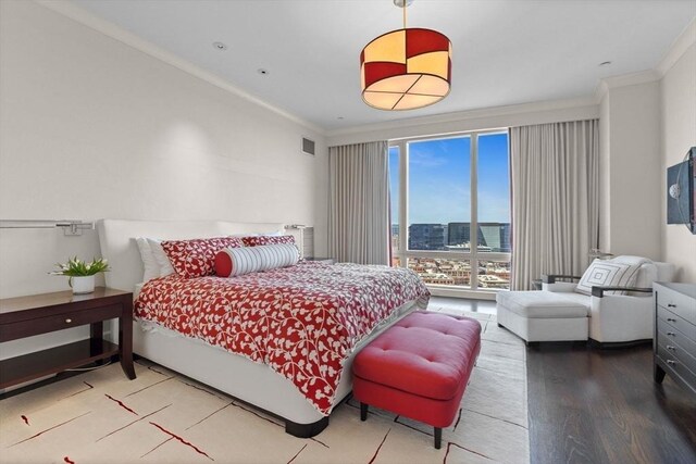 bedroom featuring crown molding and wood finished floors