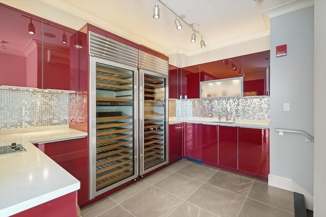 bar area with decorative backsplash, light tile patterned floors, electric cooktop, and a sink