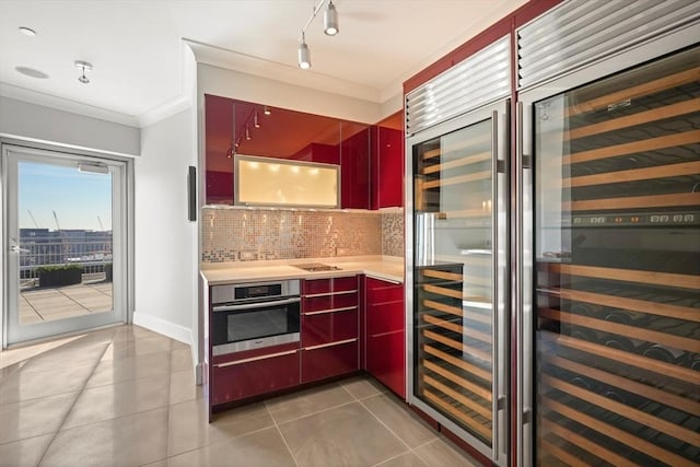 kitchen with stainless steel oven, tasteful backsplash, light tile patterned floors, crown molding, and light countertops