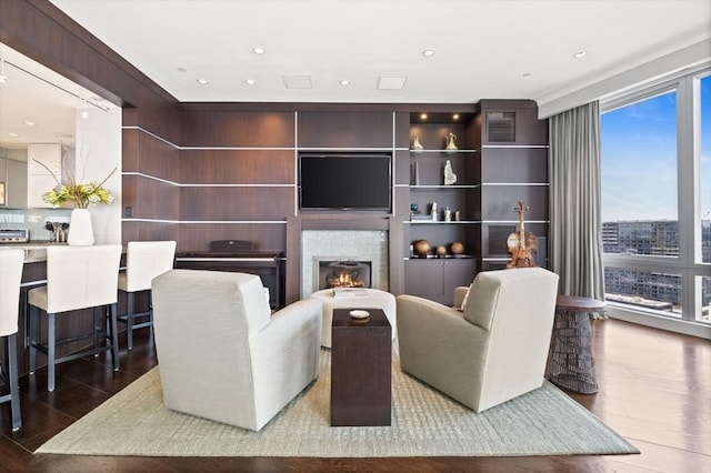 living area featuring wood finished floors, a lit fireplace, and recessed lighting