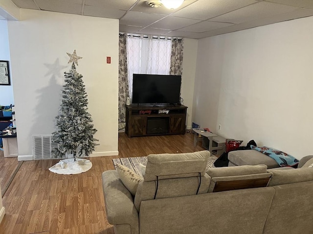 living room with hardwood / wood-style floors and a drop ceiling