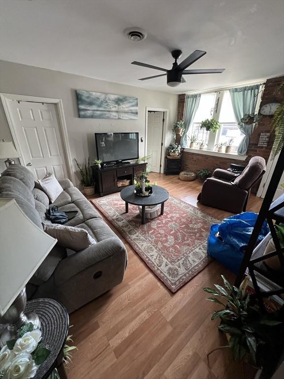 living room featuring ceiling fan and hardwood / wood-style floors