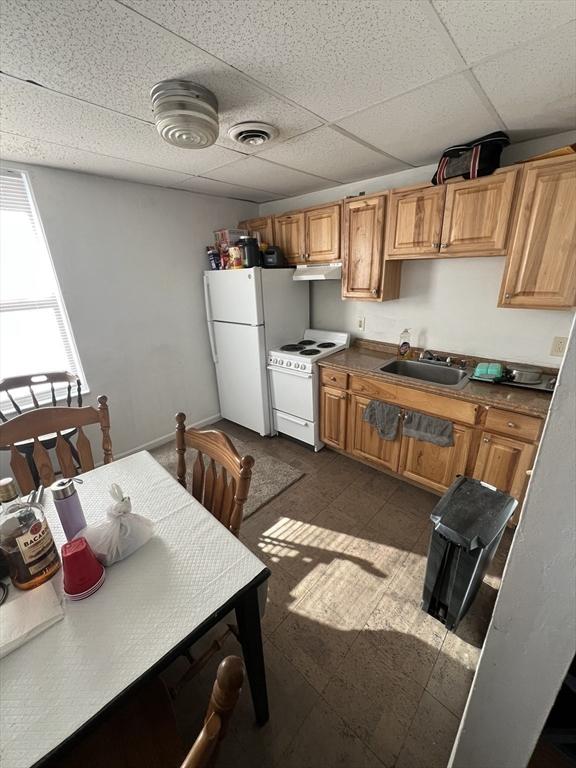 kitchen featuring sink, a paneled ceiling, and white appliances