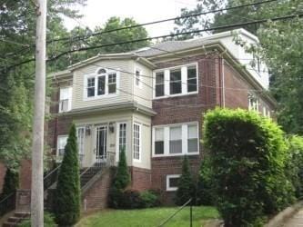 200 Winchester St Unit 1, Brookline, MA 02446 - view of front of house featuring brick siding and a front lawn