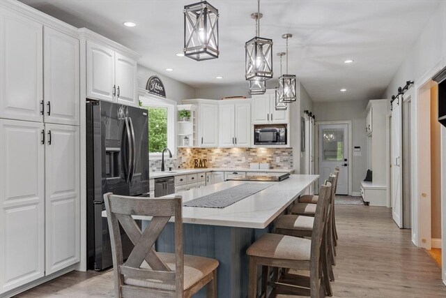 28 Sandy Ridge Rd, Sterling, MA 01564 - kitchen with black appliances, open shelves, a barn door, backsplash, and a breakfast bar
