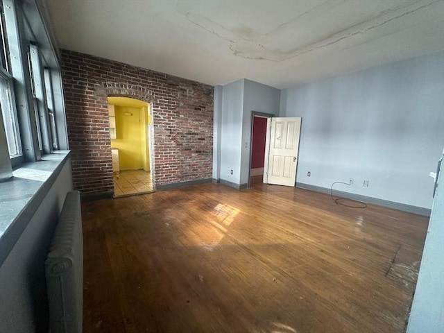 91-93 Mulberry St, Springfield, MA 01105 - empty room featuring baseboards, arched walkways, and wood finished floors