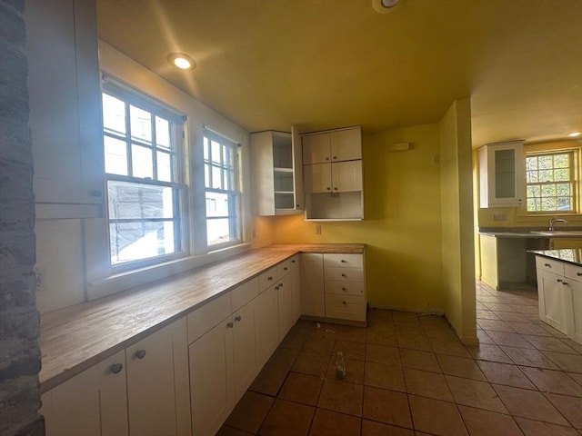 91-93 Mulberry St, Springfield, MA 01105 - kitchen featuring tile patterned flooring, glass insert cabinets, recessed lighting, white cabinets, and a sink