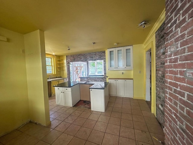 91-93 Mulberry St, Springfield, MA 01105 - kitchen featuring dark countertops, white cabinets, a kitchen island, and brick wall