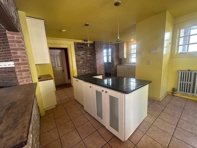 91-93 Mulberry St, Springfield, MA 01105 - kitchen featuring radiator, light tile patterned flooring, dark countertops, and white cabinets