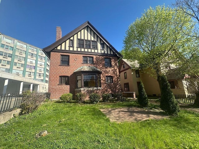 91-93 Mulberry St, Springfield, MA 01105 - back of property with fence, a chimney, a lawn, and brick siding