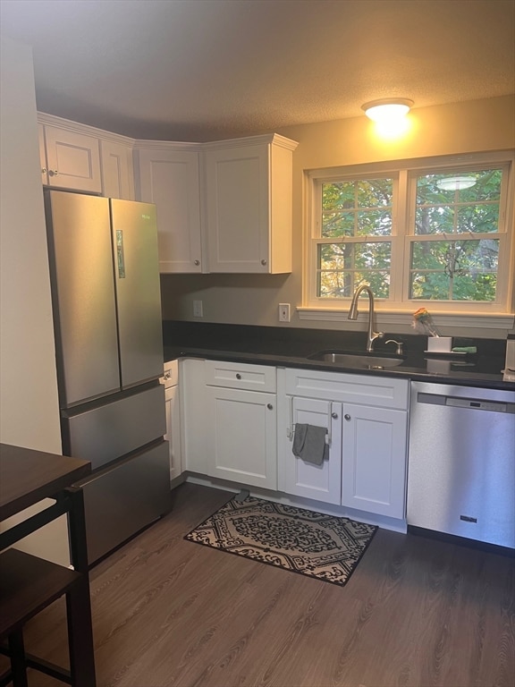 kitchen with white cabinetry, stainless steel appliances, dark wood-type flooring, and sink