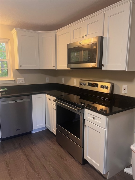 kitchen featuring appliances with stainless steel finishes, white cabinetry, and dark hardwood / wood-style floors