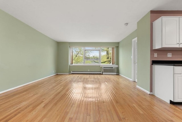 unfurnished living room featuring baseboards, light wood-style flooring, a baseboard radiator, and a wall mounted AC