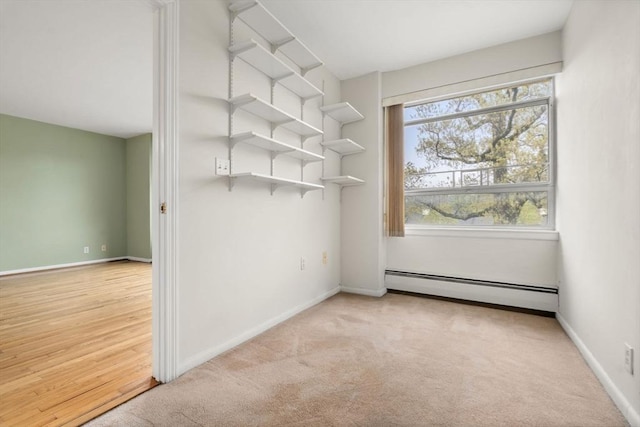 unfurnished room with baseboards, a baseboard heating unit, and carpet floors